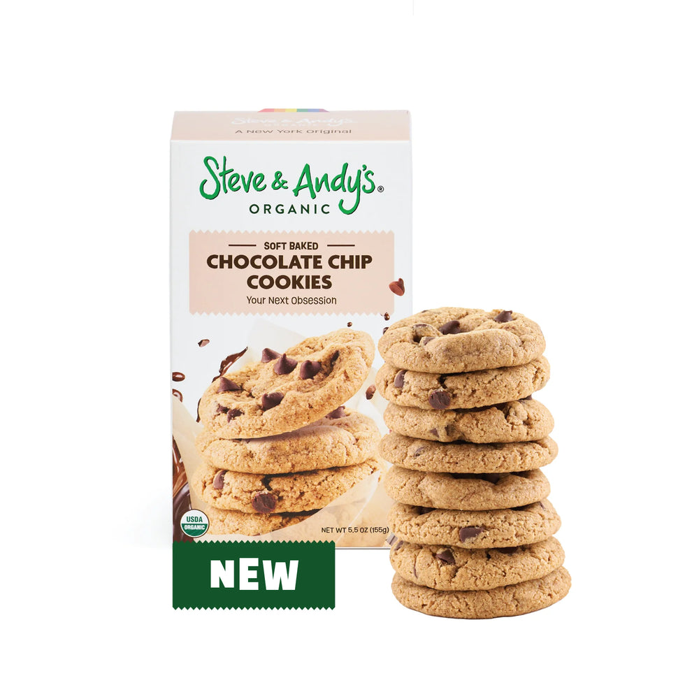 A stack of soft baked chocolate chip cookies in front of a box labeled 'Steve & Andy's Organic Soft Baked Chocolate Chip Cookies' with a 'New' sticker on the box.